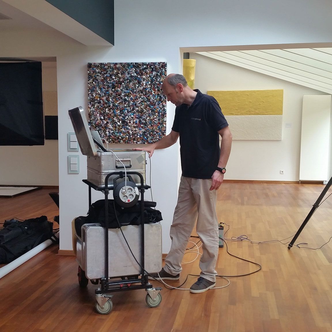 Glücklicher Mann mit Brille lächelt vor historischer Architektur im Hintergrund.